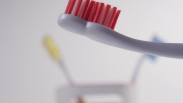 在明亮的浴室里 年轻人把蓝色牙膏压在牙刷的红色刷子上 卫生及刷牙准备工作 — 图库视频影像