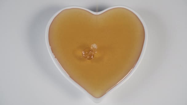 Naplnění Žlutým Včelím Medem Bílým Talířem Tvaru Srdce Bílém Kuchyňském — Stock video