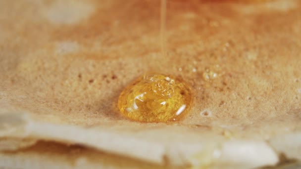 一缕金黄色的蜂蜜在一条细细的溪流中流淌在新鲜烘烤的煎饼上 Macro视频 — 图库视频影像