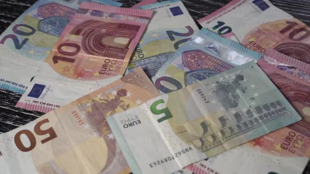 ユーロ紙幣の山では 手が上に4番目の数字と黒のサイコロを置く 黒い木製のテーブルの上 投資リスクの考え方 — ストック動画