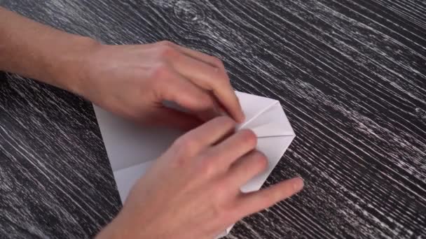Montaż Białej Papierowej Płaszczyzny Origami Czarnym Teksturalnym Drewnianym Stole Rękami — Wideo stockowe