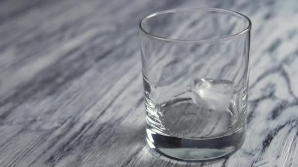 Tiefgefrorene Eiswürfel Fallen Ein Leeres Glas Für Whiskey Auf Einer — Stockvideo
