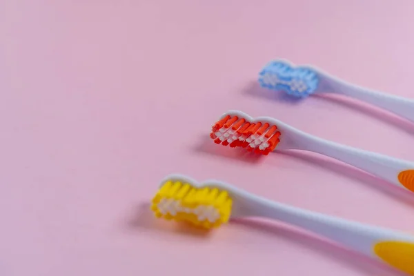 Three Bright Toothbrushes Delicate Pink Background Red Yellow Blue Family — Stock Photo, Image