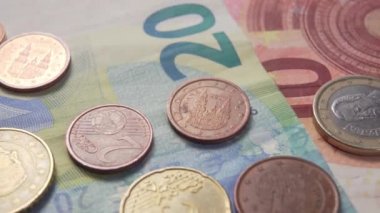 Banknotların üzerindeki Euro paraları gün ışığında parlıyor. Dolly makro shot.