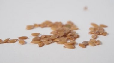 Keten tohumu beyaz mutfak masasının üzerine düşer. Makro çekim.