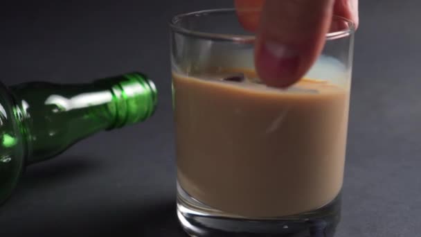 Χέρι Κουνάει Ένα Ποτήρι Ιρλανδικό Λικέρ Κρέμας Και Παγάκια Σκούρο — Αρχείο Βίντεο