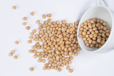 Türk bezelyeleri beyaz bir fincandan yakın plan bir masaya döküldü. Yukarıdan görüntüle