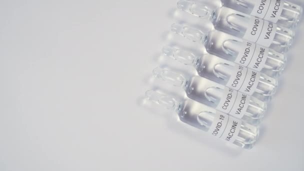 Ряд Медицинских Стеклянных Ампул Вакциной Covid Деревянной Поверхности Медленное Вращение — стоковое видео