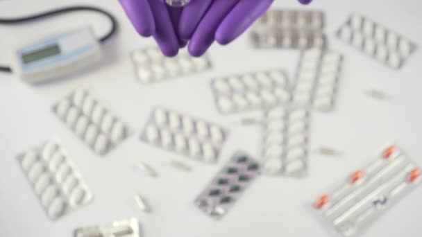 5つのガラスのアンプルのコロナウイルスワクチン 青い保護医療用手袋を手に 医療機器や薬の背景に Covid 19用医薬品の探索 — ストック動画