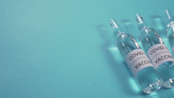 Cinco Ampolas Com Uma Vacina Contra Coronavírus Num Fundo Azul — Vídeo de Stock