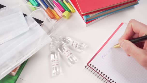 コロナウイルスワクチン 書籍や面マスクの小瓶付きの医療現場 医者はノートブックにCovid 19の薬のテスト結果を書きます — ストック動画