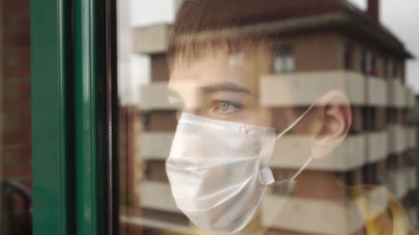 Adolescente Una Mascarilla Cuarentena Mira Tristemente Por Ventana Golpea Mano — Vídeos de Stock