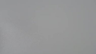 Cam bir şişeden gri plastik bir yüzeye üç beyaz kapsül döküldü. Ağır çekim. Yakın plan. Makro atış. Tıbbi konsept.