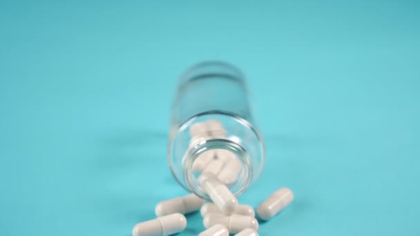 Capsules Médicinales Renversées Une Bouteille Verre Sur Une Table Bleue — Video