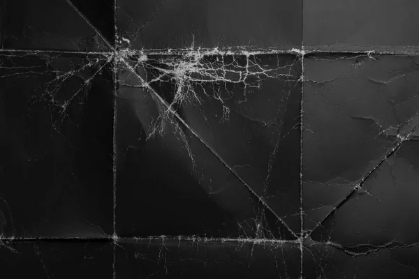 Kırışık ve ovulmuş köşeli buruşuk siyah kağıt. Eski paket tozlu karton. Soyut dramatik arka plan. Tasarım ve başlıklar için.