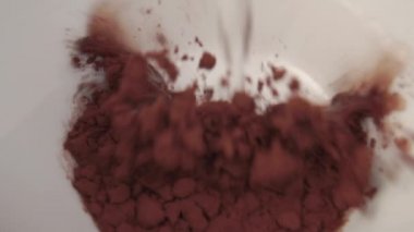 Sıcak su akıntısı beyaz bardağa kakao tozu ile doldurulur. Anında besleyici kahvaltı içeceği. Yakın plan. Makro çekim