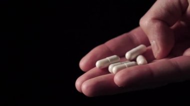 Siyah arka planda beyaz tıbbi kapsüller var. Coronavirus tıbbi tedavi konsepti