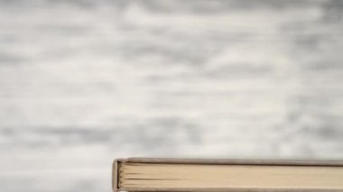 Kitaplar ve ders kitapları gri ahşap bir kütüphane rafında. Kamerayı tepeden tırnağa izle. Ağır çekim. Uzaktan öğrenme ve çalışma kavramı