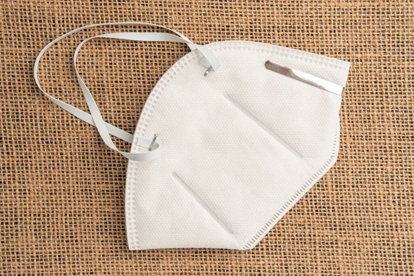 Çuval bezinin soyut arka planında solunum maskesi kn95 ffp2. Koronavirüsten koruma ve önleme. Satılık koruyucu maskelerin olmaması fikri