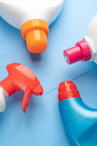 Jasne Wielokolorowe Detergenty Plastikowych Butelkach Cieczy Sprayu Jasnoniebieskim Drewnianym Tle — Zdjęcie stockowe