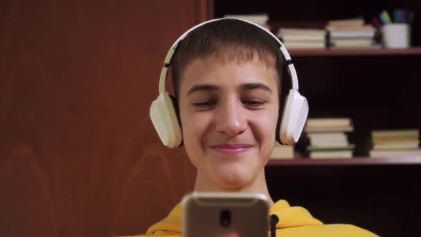 Joven Estudiante Auriculares Inalámbricos Blancos Juega Escribe Teléfono Inteligente Fondo — Vídeos de Stock