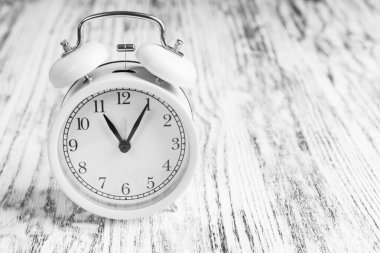 Ahşap doku arka planında klasik analog alarm saati. Dramatik siyah beyaz manzara. Kopyalama. Finansal koronavirüs krizi konsepti