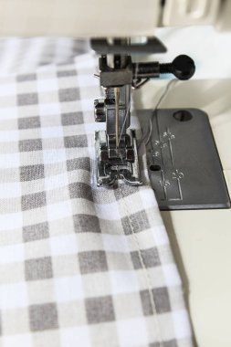 Sewing machine with fabric and thread on a whine background. Close up and copy space.