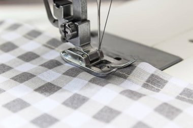 Sewing machine with fabric and thread on a whine background. Close up and copy space.