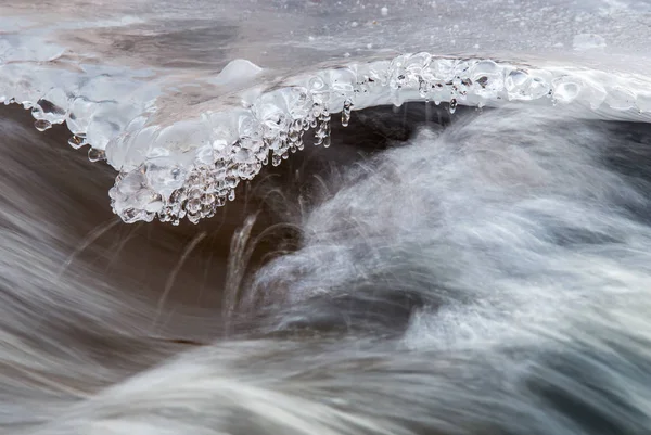 Eiszapfen über dem Wasserfluss — Stockfoto