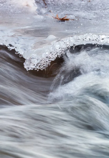 Eiszapfen über dem Wasserfluss — Stockfoto