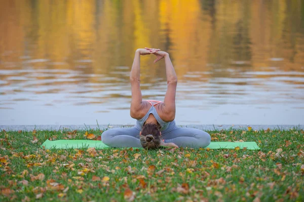 genç kadın sonbahar Şehir Parkı Nehri yakınında Yoga yapıyor