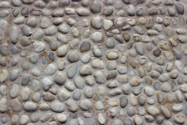 Taş duvar dokusu, küçük yuvarlak ve deniz taşlarından yapılmış yol.