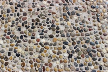 Taş duvar dokusu, küçük yuvarlak ve deniz taşlarından yapılmış yol.