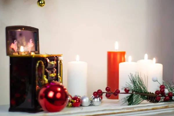 Music box, burning candles, still life on the fireplace new year