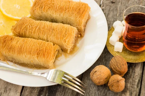 Kadayif dans une assiette avec citrons et thé — Photo