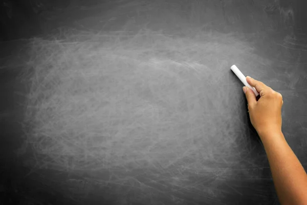 Black chalkboard with hand holding chalk — Stock Photo, Image