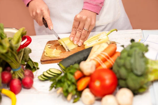 Woman cutting bell pepper on slices — Stock Photo, Image