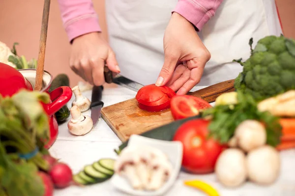 Vrouw tomaat snijden in de keuken — Stockfoto