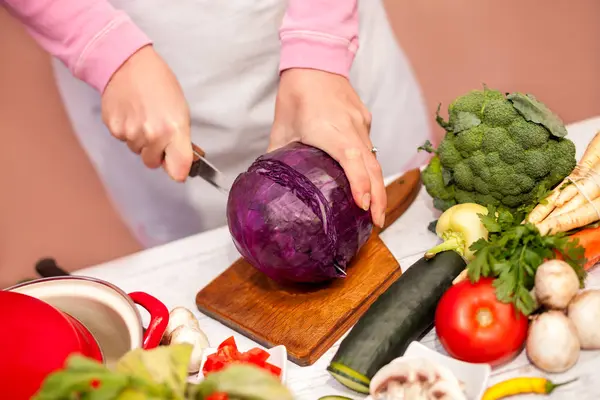 Kobieta w kuchni cięcia czerwona kapusta — Zdjęcie stockowe