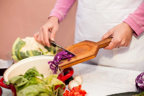 Frau legt Rotkohlscheiben in die Küchentafel — Stockfoto