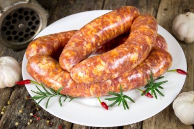 Biberiye ve plaka üzerinde pul biber ile çiğ sosis
