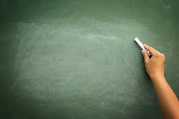 Green chalkboard with hand holding chalk — Stock Photo, Image