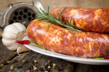 Biberiye, biber ve biber ile plaka üzerinde çiğ sosis