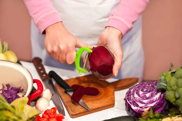 Donna che affetta la barbabietola, preparazione di verdure in cucina — Foto Stock