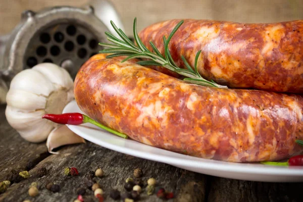 Biberiye, biber ve biber ile plaka üzerinde çiğ sosis