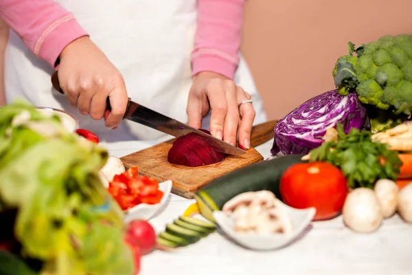 Housewife with a knife cutting beetroot, vegetable cutting in th — Stock Photo, Image