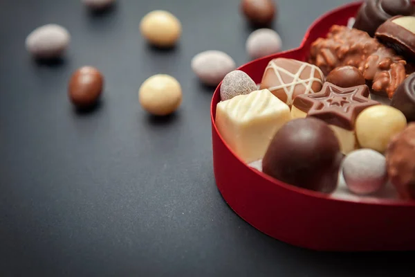 Close shot of chocolate pralines in heart shaped box — Stock Photo, Image