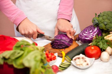 Kırmızı lahana doğrama kurulu üzerinde bir bıçak ile dilimleme