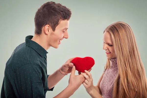 Romantische vriendje gifting een rood hart aan een vriendin — Stockfoto