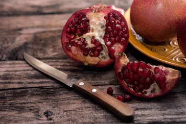 Masanın üzerinde bir bıçakla soyulmuş nar